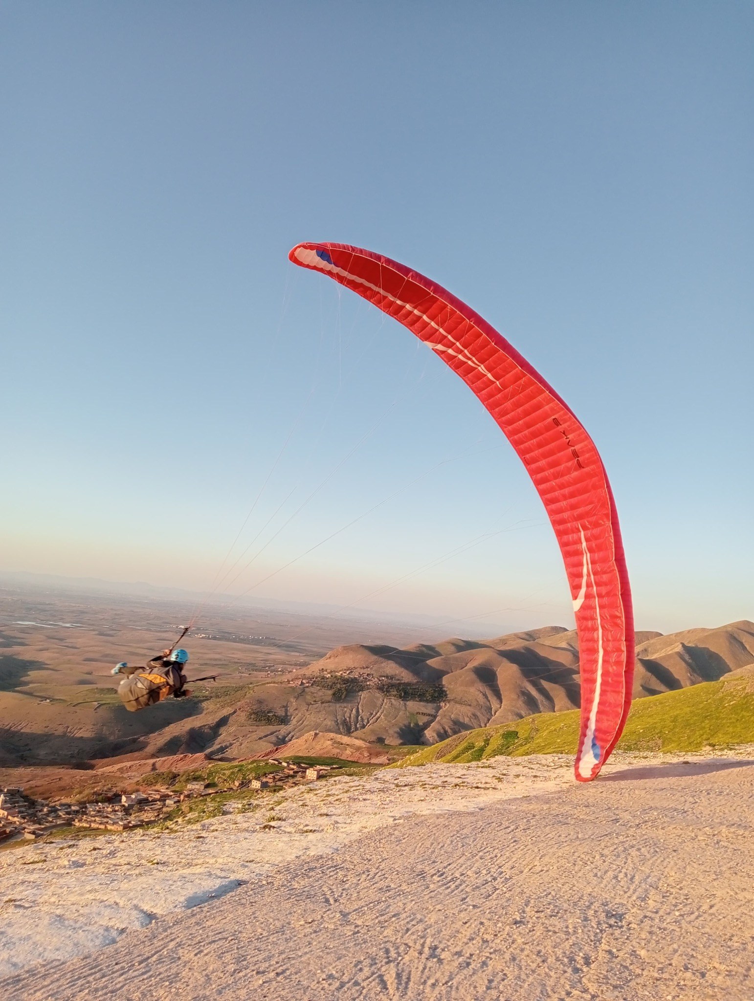 Parapente rouge au décollage